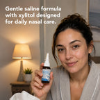 Woman using ioMist nasal spray at bedtime: gentle saline formula with xylitol for daily nasal care