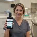 Dental hygienist holding ioRinse Professional Concentrate Green Apple in a dental office