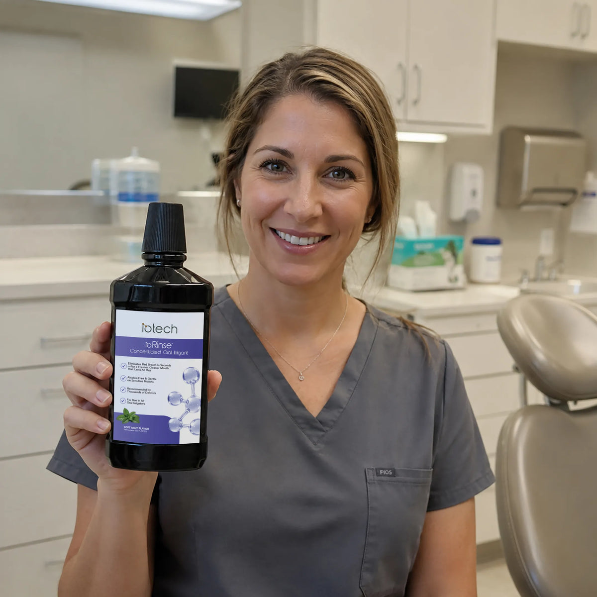 Dental hygienist holding ioRinse Professional Concentrate Soft Mint in a dental office